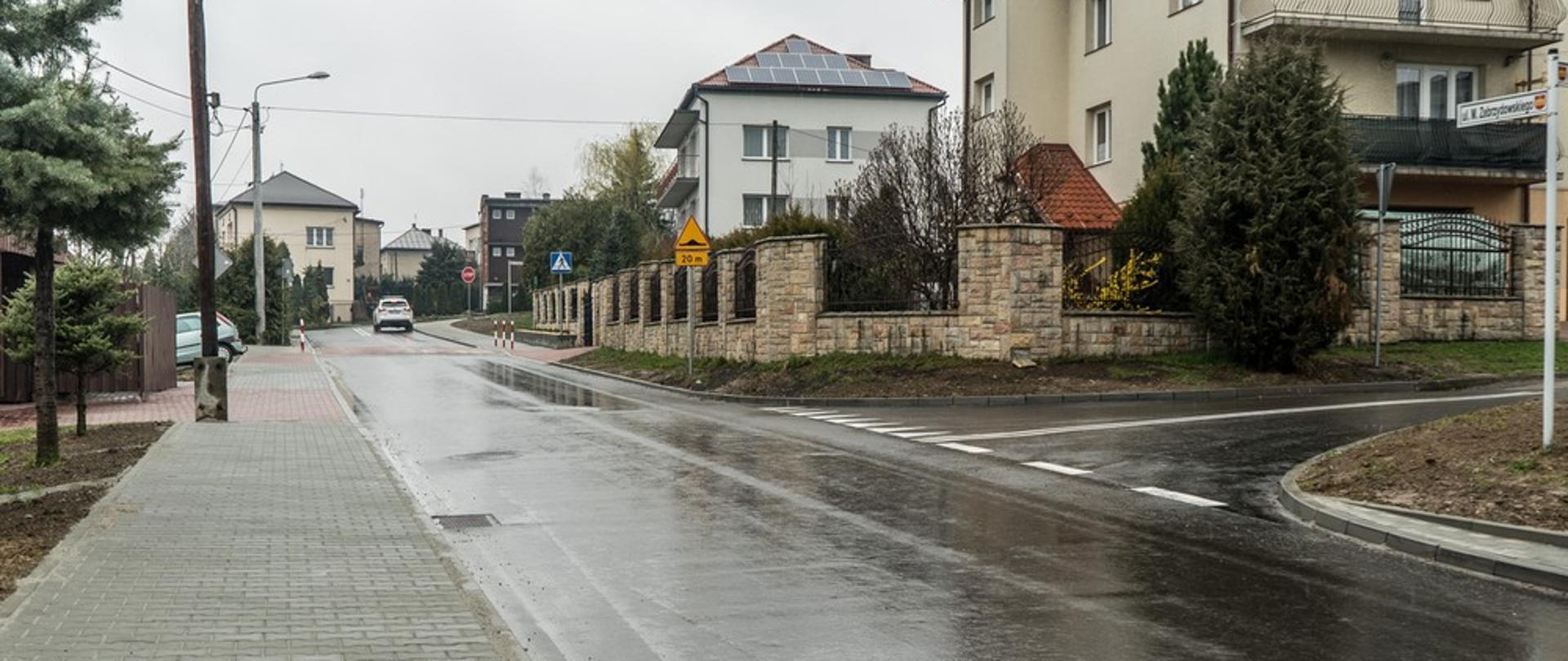 Ulica Piłsudskiego w Kalwarii Zebrzydowskiej. Po lewej stronie chodnik z prawej strony oraz w tle domy jednorodzinne.