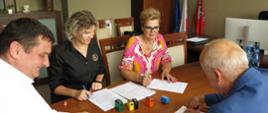 Przy stole siedzą: wicestarosta Michał Michaluk, skarbnik Anna Sulińska, starosta Bożena Niedzielak, i Wykonawca, podpisują umowę. 