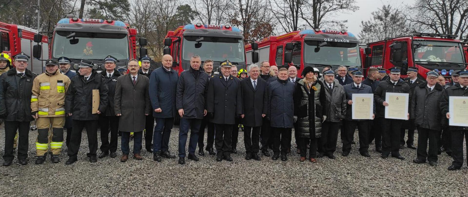 Delegacje regionu radomskiego, biorące udział w wydarzeniu na tle wozów bojowych straży pożarnej.