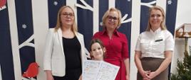 Dyrekcja Przedszkola wraz z przedstawicielką Nadleśnictwa Hajnówka wręczają nagrody dzieciom, pozując do wspólnego zdjęcia