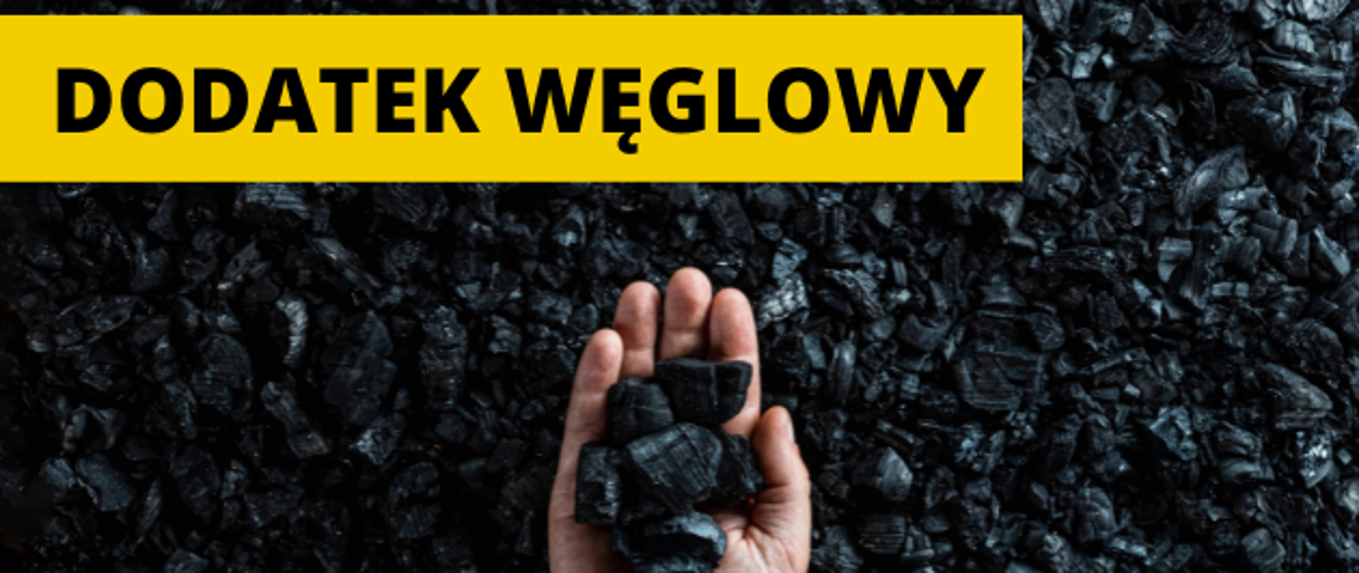 Zdjęcie dłoni trzymającej bryły węgla z podpisem "dodatek węglowy"