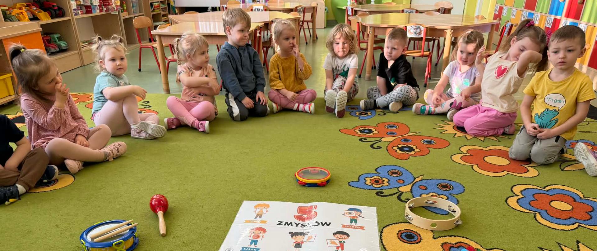 Dzieci siedzące w kole oglądające instrumenty