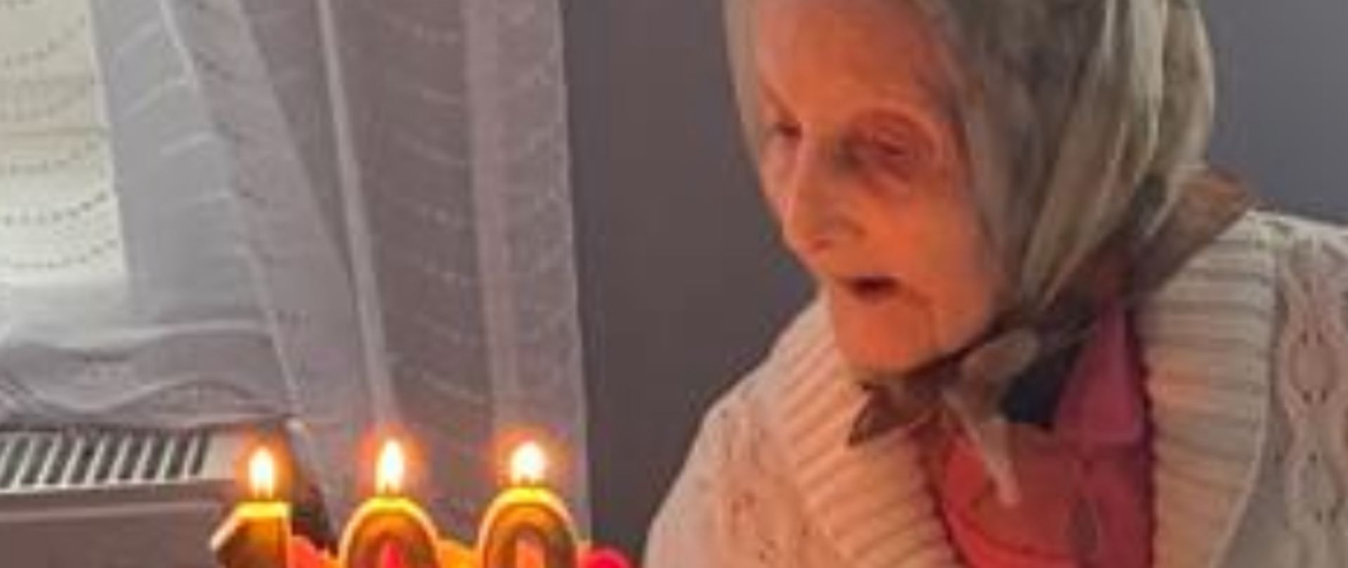 Jubilatka zdmuchuje świeczki z urodzinowego tortu