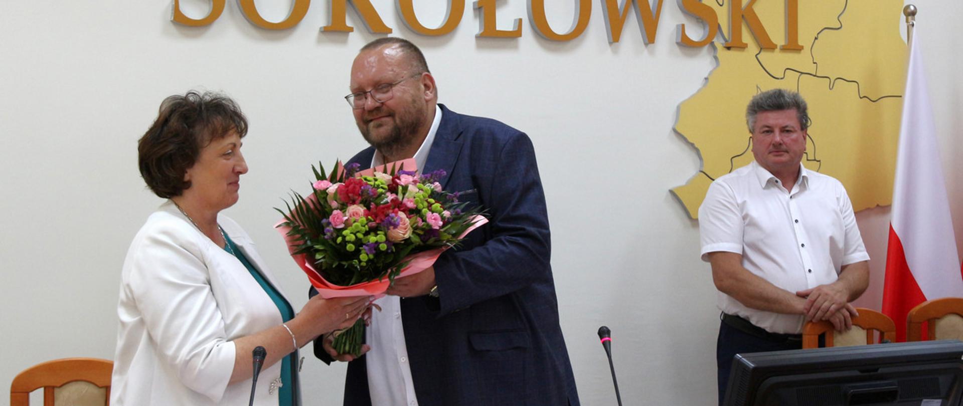 Na fotografii moment po uzyskaniu przez Zarząd Powiatu absolutorium za 2022 r. Przewodniczący Rady Powiatu wręcza Staroście Sokołowskiemu bukiet kwiatów w uznaniu za pracę Zarządu Powiatu Sokołowskiego.