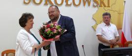 Na fotografii widzimy radnych Rady Powiatu Sokołowskiego w trakcie obrad, którzy siedzą przy stole w sali konferencyjnej Starostwa Powiatowego w Sokołowie Podlaskim.