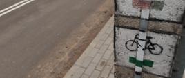 Znaki turystyczne na słupie elektrycznym - w tle nowo przebudowana droga i chodniki
