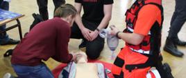 Uczniowie biorą udział w prezentacji pomocy społecznej z udziałem manekina 
