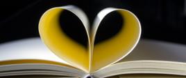 Zdjęcia przedstawia otwartą książkę której wygięte środkowe kartki tworzą kształt serca