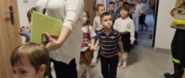 Dzieci w trakcie ewakuacji są wyprowadzane z sali