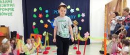 Dzieci ubrane w przygotowane przebrania z recyklingu, idą po "wybiegu" - kolorowym dywanie