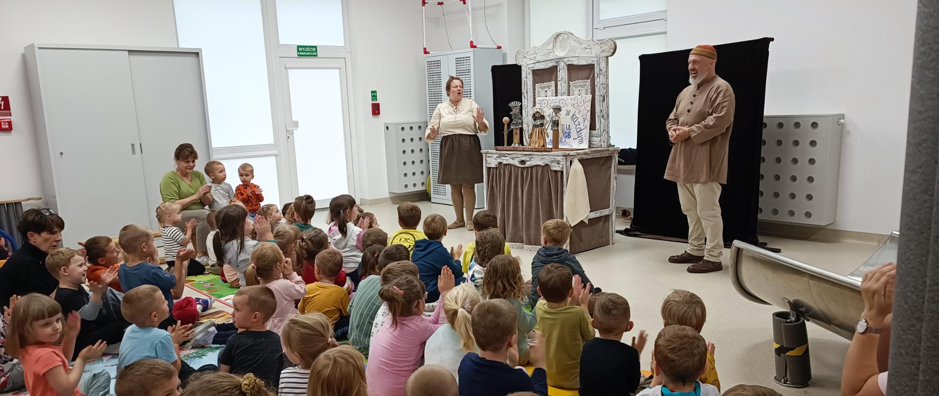 Dzieci oglądają sztukę teatralną z udziałem aktorów