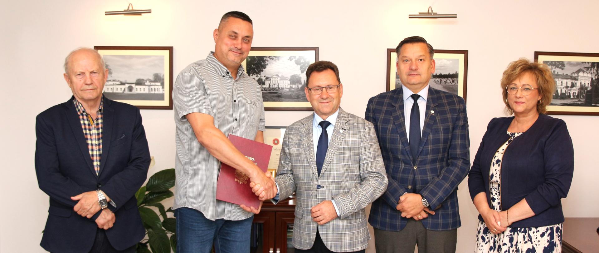 Na zdjęciu przedstawiciele Powiatu Sokołowskiego z wykonawcą inwestycji. Starosta ściska dłoń wykonawcy.