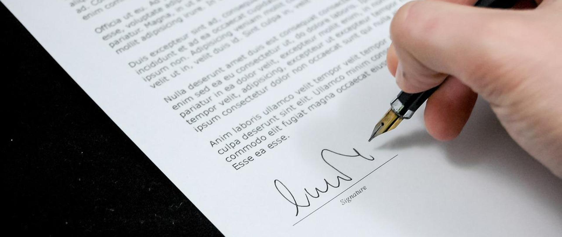 zdjęcie wycinka dokumentu w trakcie podpisywania piórem