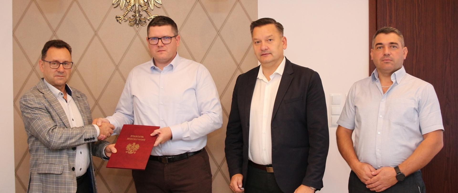 Zdjęcie wykonane w siedzibie Starostwa Powiatowego w Sokołowie Podlaskim, od lewej starosta w uściśnięciu dłoni z przedstawicielem konsorcjum budowlanego, następnie wicestarosta i skarbnik Powiatu.