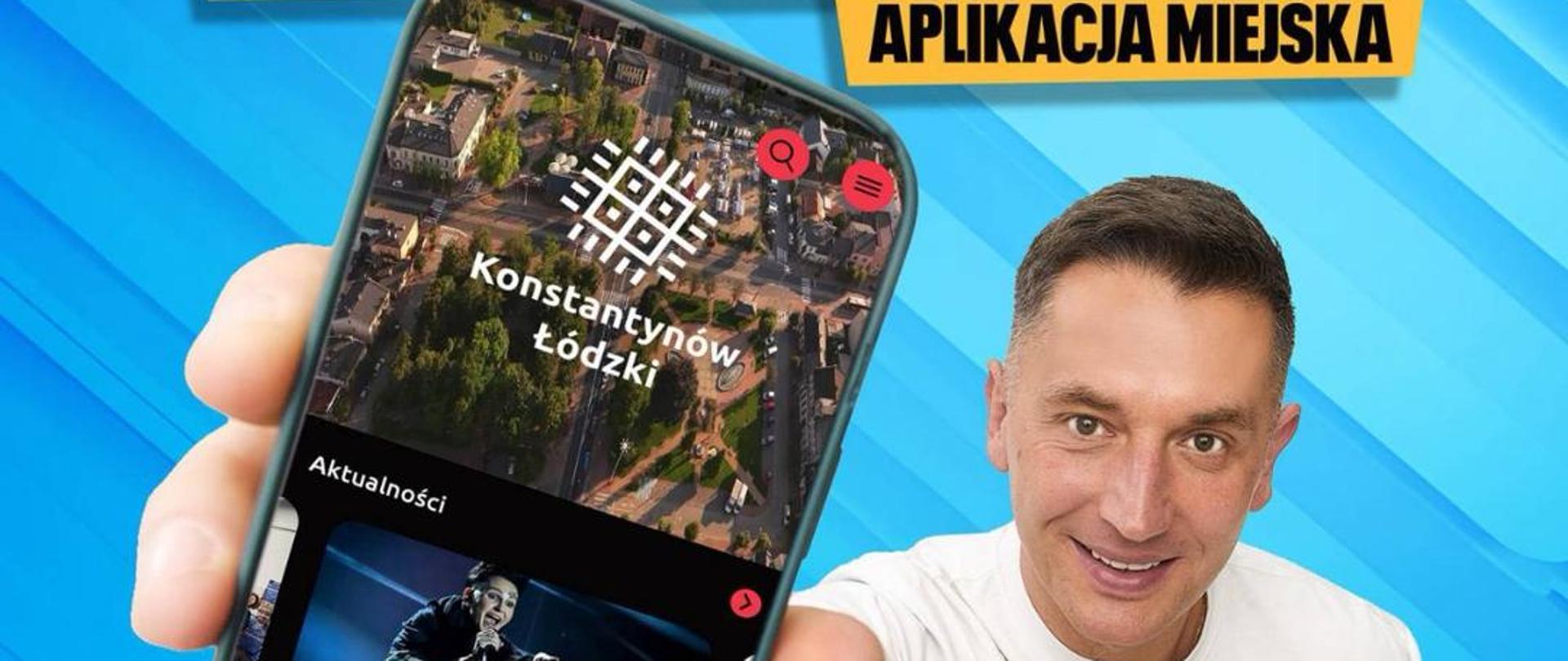 Plakat przedstawia Burmistrza Miasta Konstantynowa Łódzkiego Roberta Jakubowskiego. Włodarz miasta trzyma w dłoni telefon z grafiką aplikacji. 