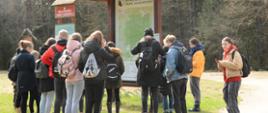 Uczniowie przy tablicy informacyjnej Białowieskiego Parku Narodowego