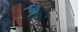 Wywóz elektrośmieci, pralka ładowana na ciężarówkę.