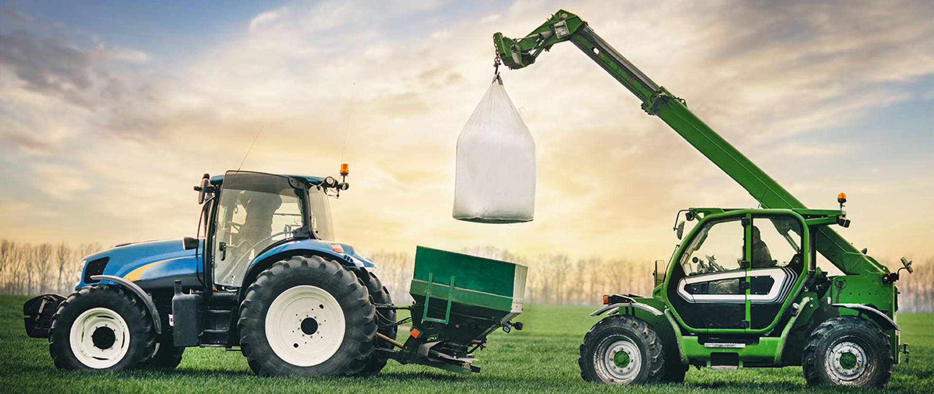 Ilustracja przedstawia dwie maszyny rolnicze ciągnik, oraz ładowarkę z pojemnikiem big-bag na polu