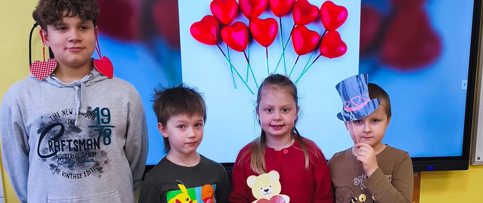 Uczniowie klasy I pozują z walentynkowymi rekwizytami