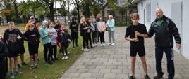 Starsi sportowcy odbierają puchary od organizatora