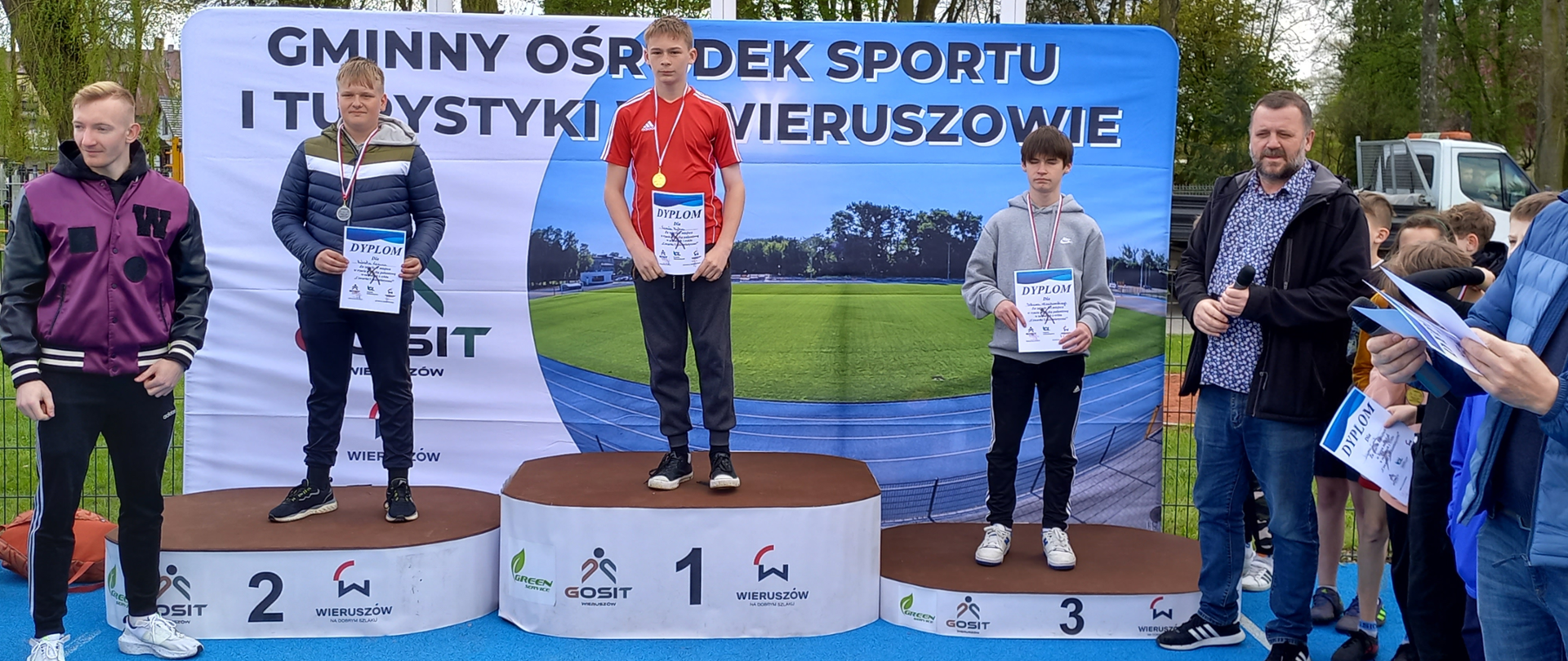 Kamil_na_I_stopniu_podium_w_rzucie_piłeczką_palantową
