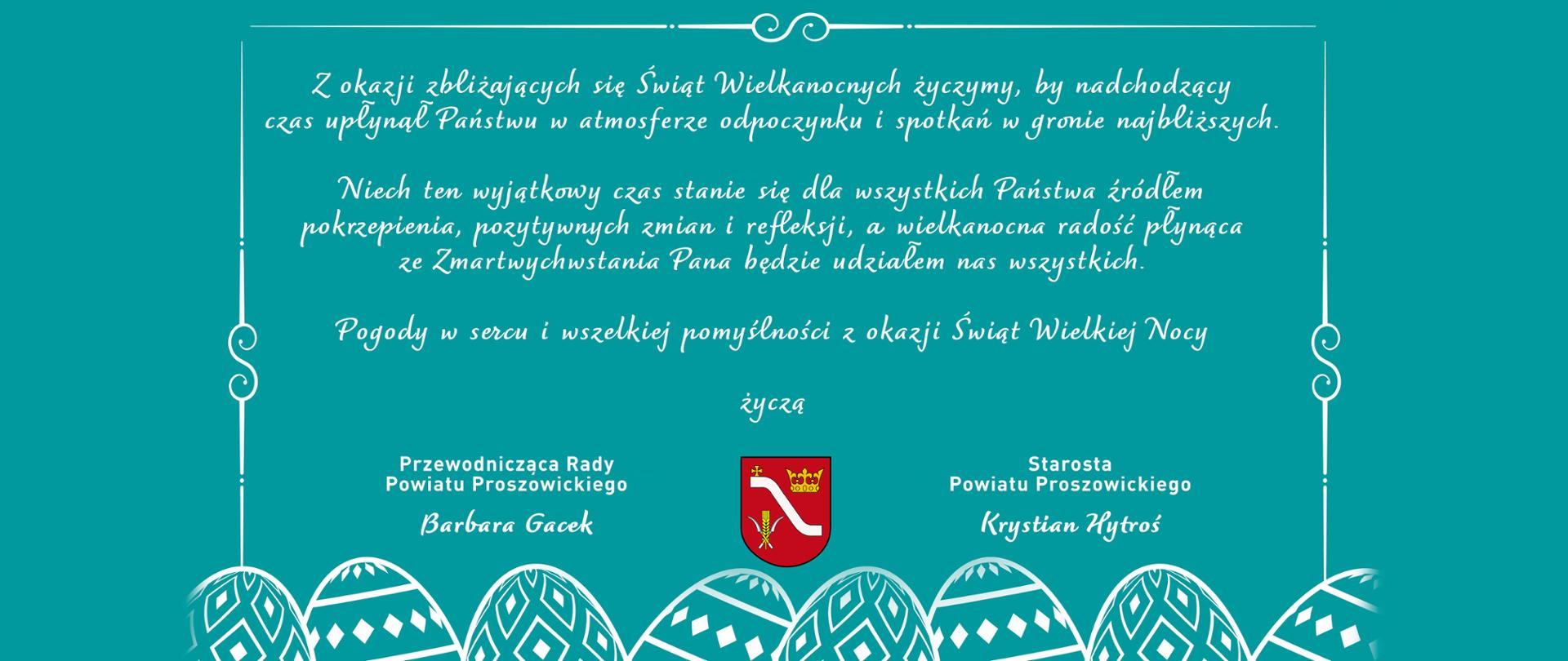 Na morskim tle życzenia z okazji Świąt Wielkanocnych od Starosty Powiatu Proszowickiego i Przewodniczącej Rady Powiatu Proszowickiego, pod treścią życzeń herb powiatu, w dole pisanki.