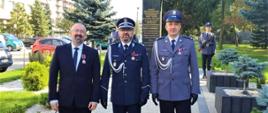 Zdjęcie przedstawia Starostę Przasnyskiego Krzysztofa Bieńkowskiego (od lewej) oraz dwóch policjantów (na prawo od Starosty) odznaczonych za zaangażowanie i pracę na rzecz bezpieczeństwa w powiatach i całym Mazowszu. Teren Komendy Wojewódzkiej Policji w Radomiu, w tle pomnik pamięci policjantów II RP pomordowanych na wschodzie przez NKWD w latach 1939-1945.