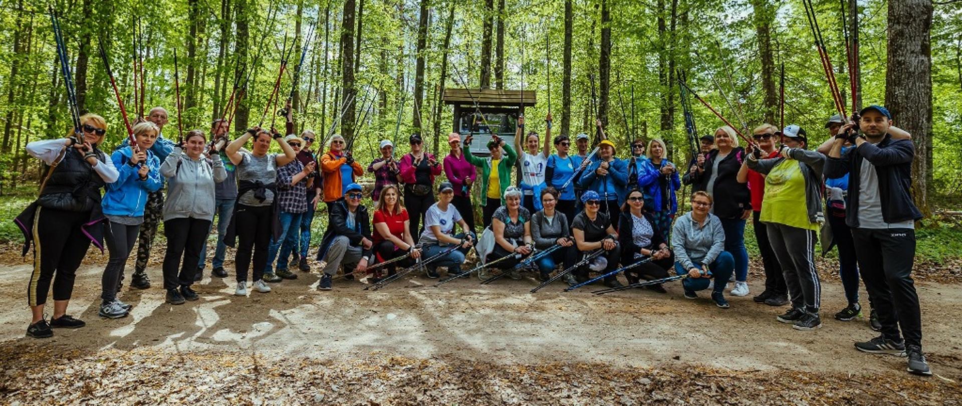 Rajd nordic walking - uczestnicy wydarzenia pozują do wspólnego zdjęcia