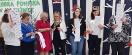 Nauczycielki z przedszkola w trakcie odczytu z kartek imitujących drzewo