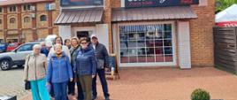 Uczestnicy wyjazdu pozują do wspólnego zdjęcia przed budynkiem pizzerii