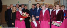 Kobiety w różowych strojach, mężczyźni w kapeluszach pozują do wspólnego zdjęcia 