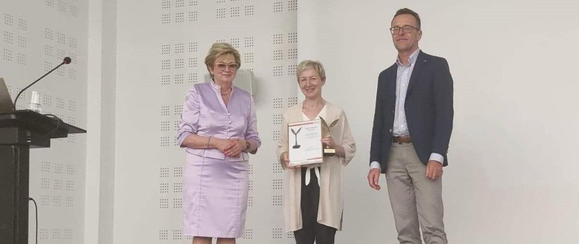 Wicedyrektor ZSM Barbara Łabędzka odbiera statuetkę i certyfikat potwierdzający wysoką jakość kształcenia w ZSM
