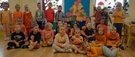 Wspólne zdjęcie wszystkich przedszkolaków na tle dekoracji z okazji Dnia Dyni.
