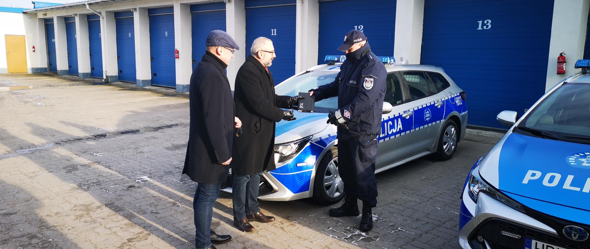 Na zdjęciu Starosta Krzysztof Bieńkowski i Wójt Gminy Jednorożec Krzysztof Iwulski przekazują klucze i dokumenty do nowego radiowozu policjantowi z Powiatowej Komendy Policji w Przasnyszu.