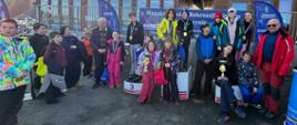 Grupa młodzieży z opiekunami pozuje do zdjęcia z medalami i pucharami