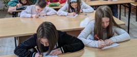 Uczniowie i uczennice piszą dyktando