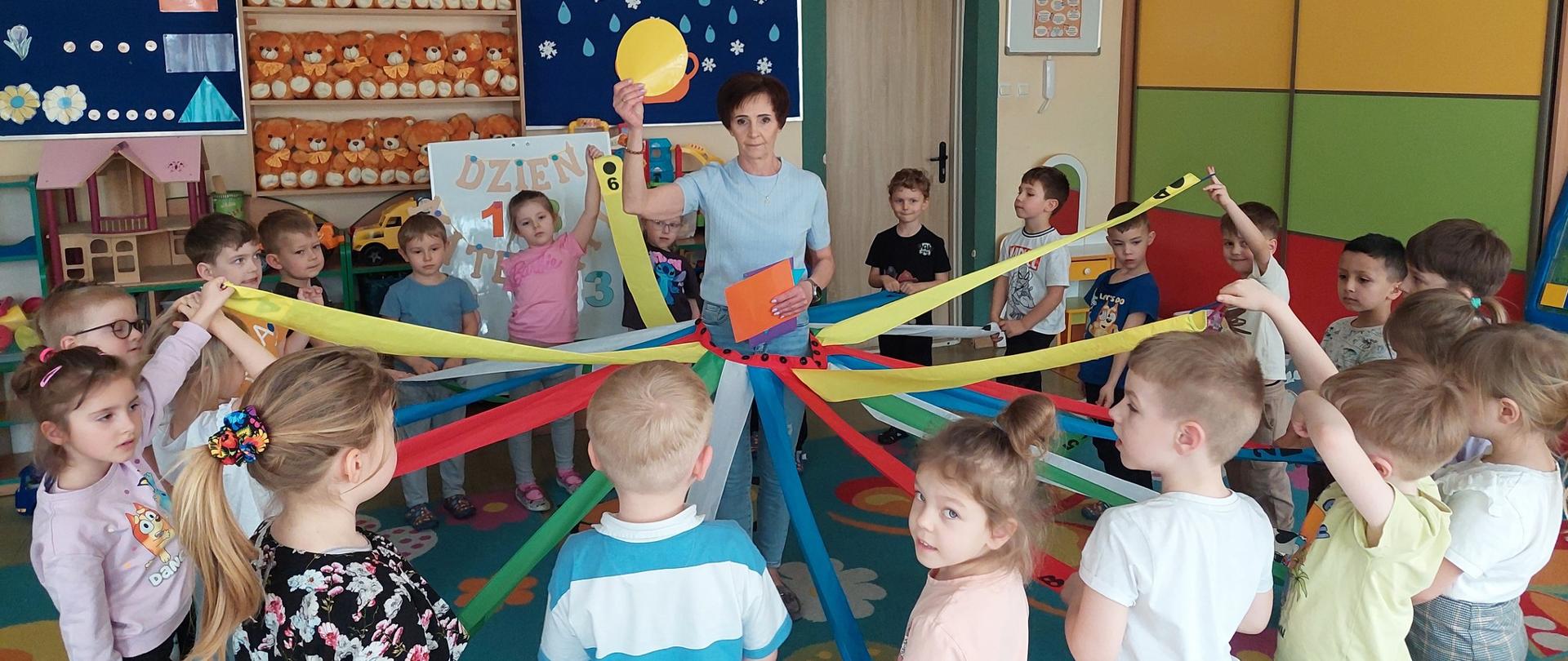 Grupa dzieci z szarfami wokół nauczyciela 