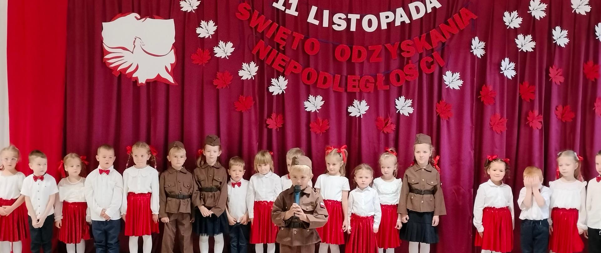 Grupa dzieci ubrana na galowo, czworo w strojach żołnieży