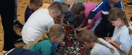Uczniowie budują modele radia z klocków COBI podczas warsztatów.