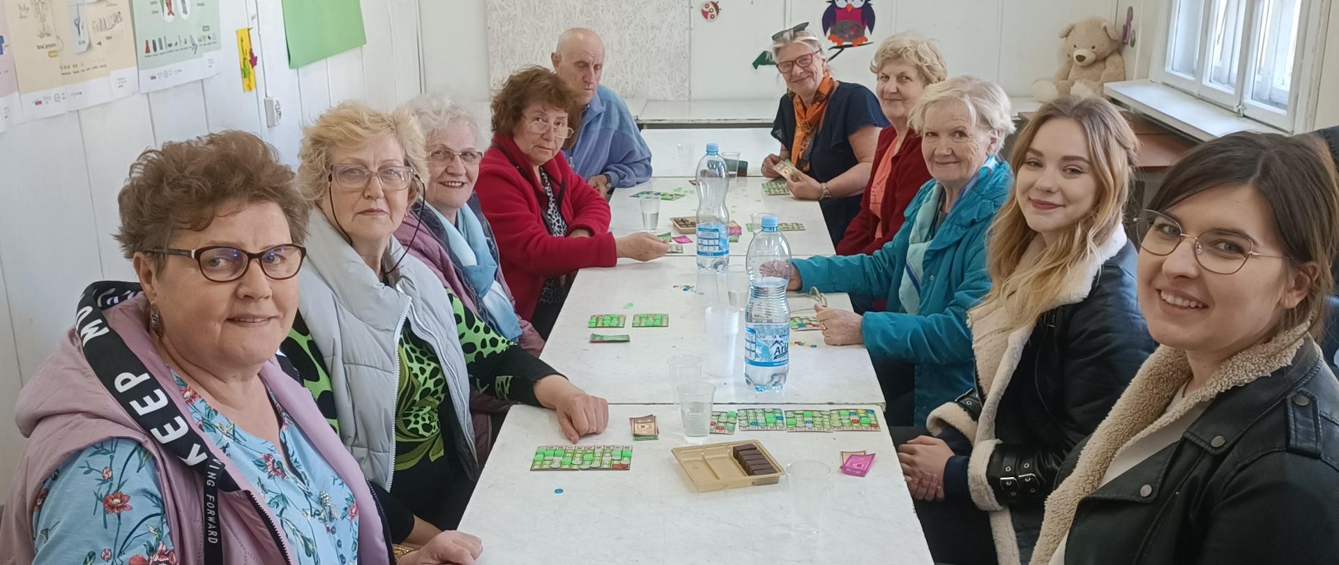 Członkowie Klubu Senior+ na spotkaniu z okazji "Tygodnia Bibliotek", grający w Bingo
