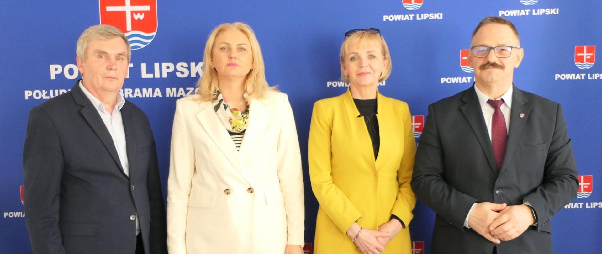 Uczestnicy spotkania. W tle granatowa ścianka z herbem Powiatu Lipskiego oraz napisem Powiat Lipski - Południowa Brama Mazowsza