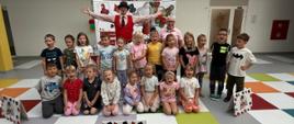 Grupa dzieci pozuje do zdjęcia z opiekunami