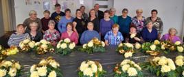 seniorzy uczestniczący w warsztatach florystycznych, wykonują m.in. wieńce na groby