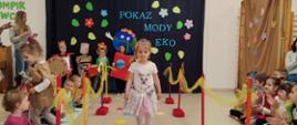 Dzieci ubrane w przygotowane przebrania z recyklingu, idą po "wybiegu" - kolorowym dywanie