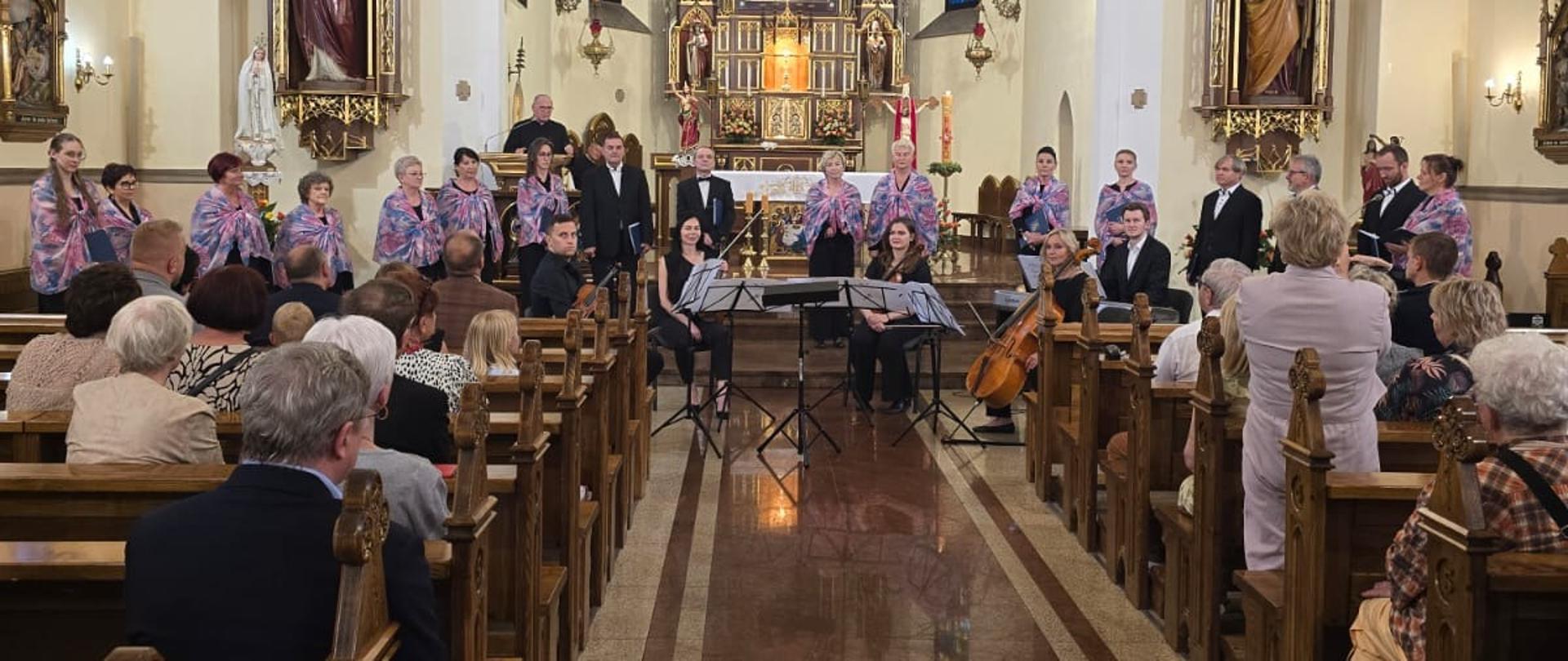 Kobiety w fioletowych strojach śpiewają przed kościelnym ołtarzem.