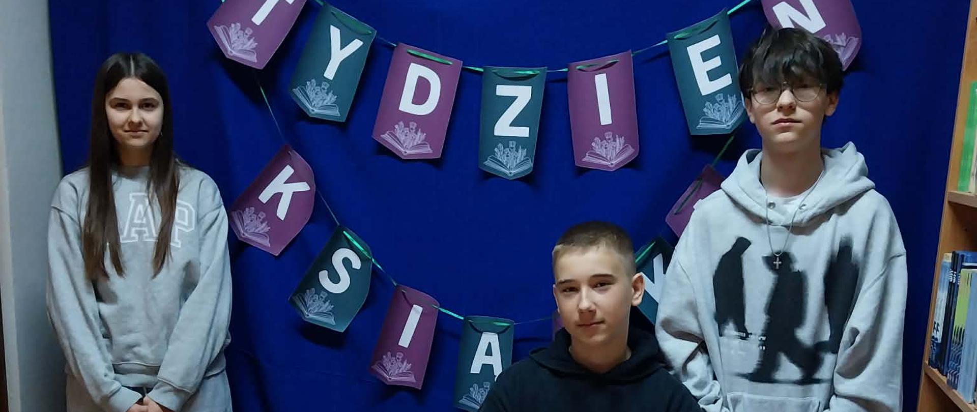 uczniowie pozują na tle napisu tydzień książki