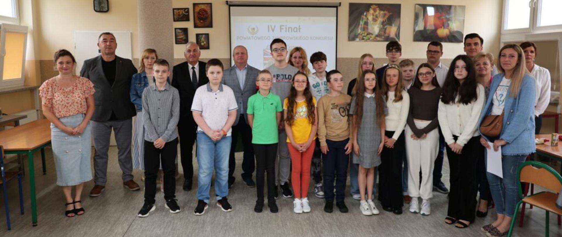 Grupowe zdjęcie na którym znajdują się: organizatorzy, sponsorzy nagród, nauczyciele, finaliści o raz rodzice
