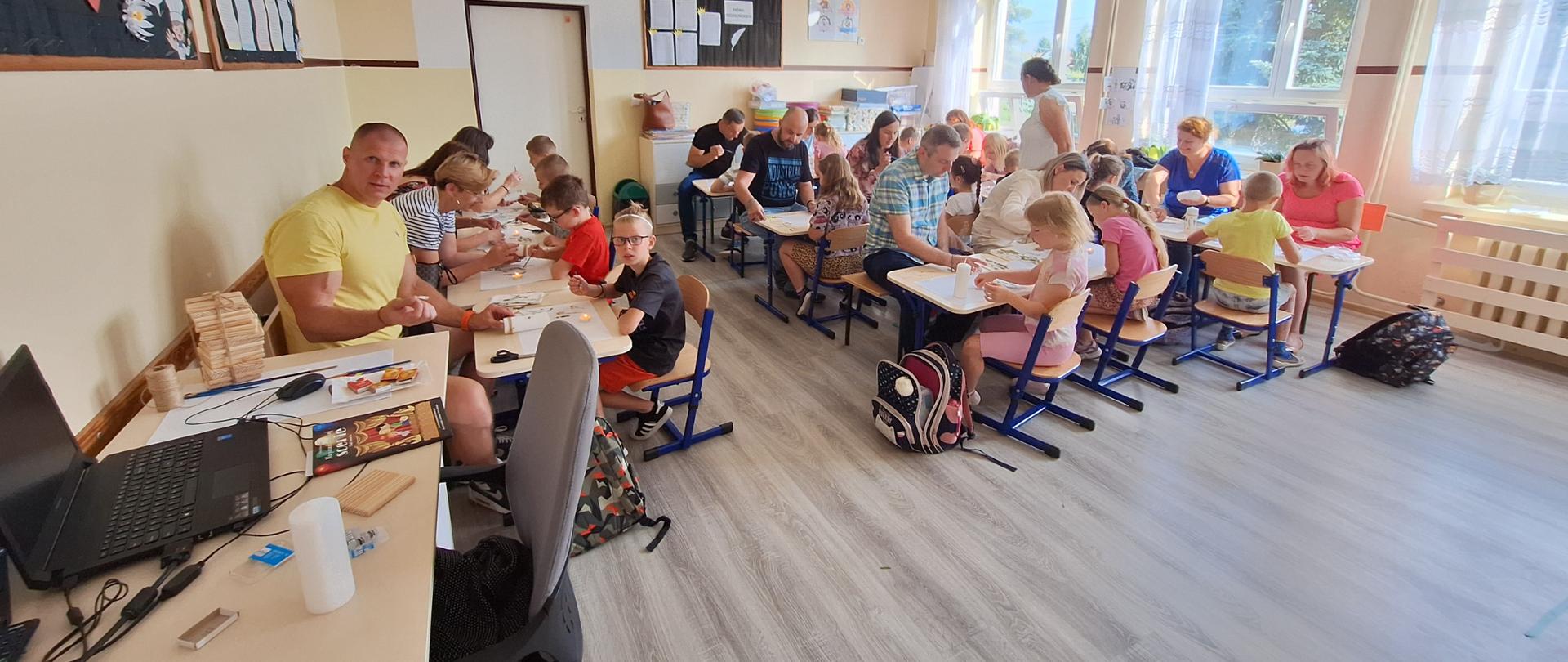 Dzieci z rodzicami ozdabiają świece