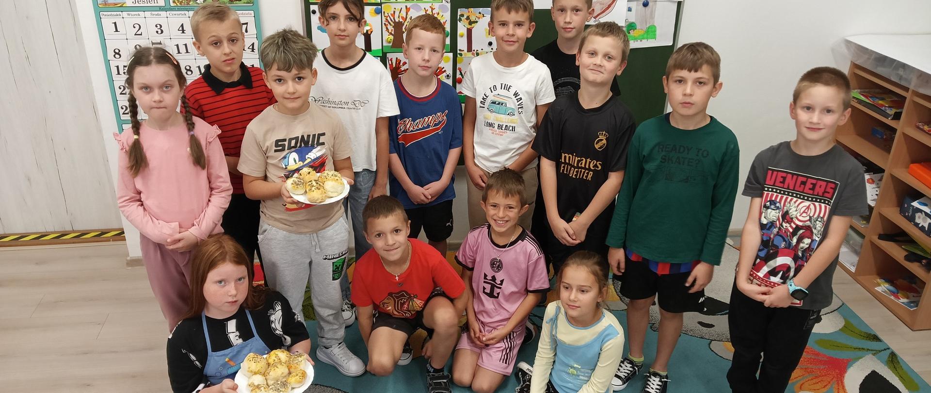 Dzieci prezentują upieczone bułeczki.