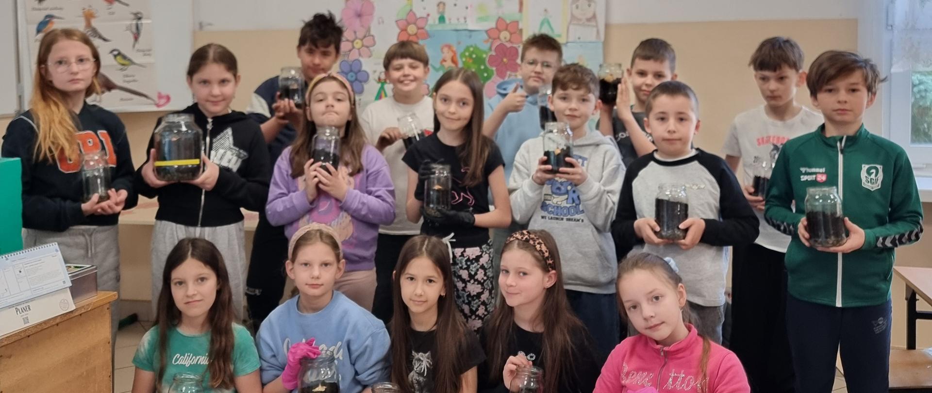 Uczniowie klasy 3a z posadzonymi do słoików cebulkami.